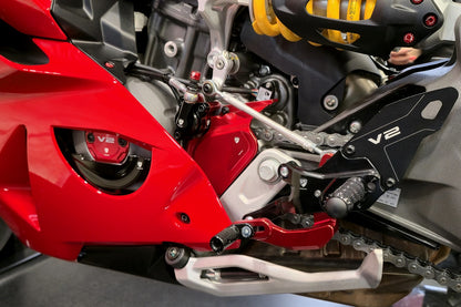 Detailbeeld van de rode CNC Racing voortandwielcover gemonteerd op Ducati Panigale V2, samen met andere CNC Racing componenten.