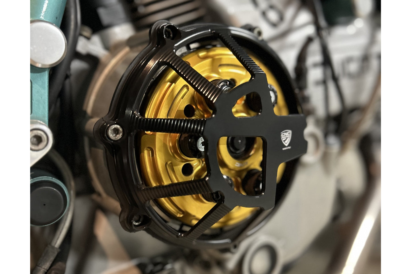 Koppelingsdeksel Traffic Ducati Monster 1100 S (2009-2015) vooraanzicht in zwart met gouden drukplaat en zwarte veren plus schotels